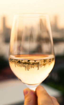 Glass of white wine with skyline reflected